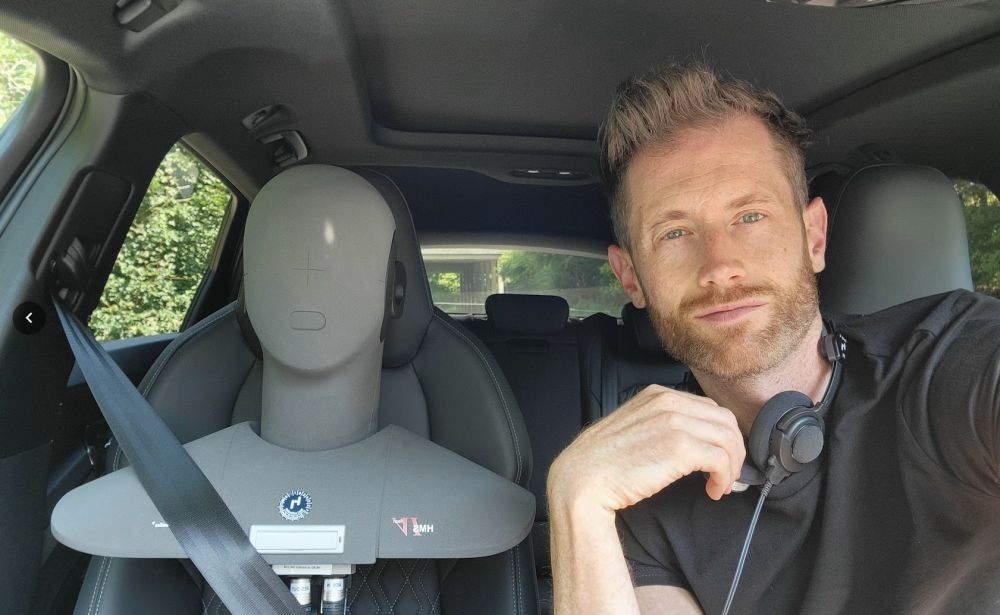 Jonathan Benson dans une voiture d’essai, avec une tête de mesure acoustique sur le siège passager