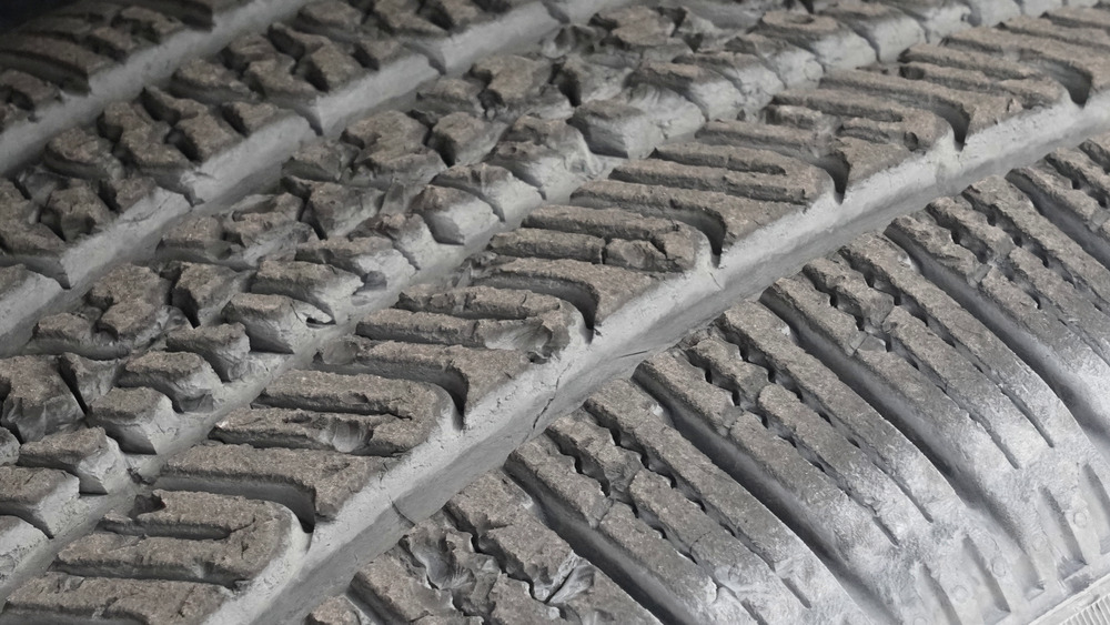 Gros plan sur les pavés de sculpture ébréchés et arrachés du Pirelli Scorpion AS Plus 3 après les essais hors route